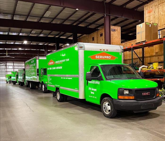 5 Green SERVPRO trucks in a warehouse in Atlanta waiting to be dispatched to a water restoration project.